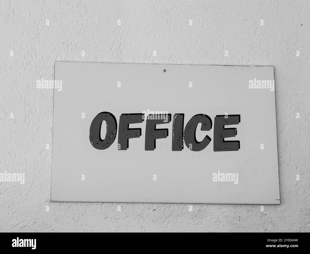 « Bureau » : signez des lettres sur fond de mur blanc – Une déclaration minimaliste. Banque D'Images