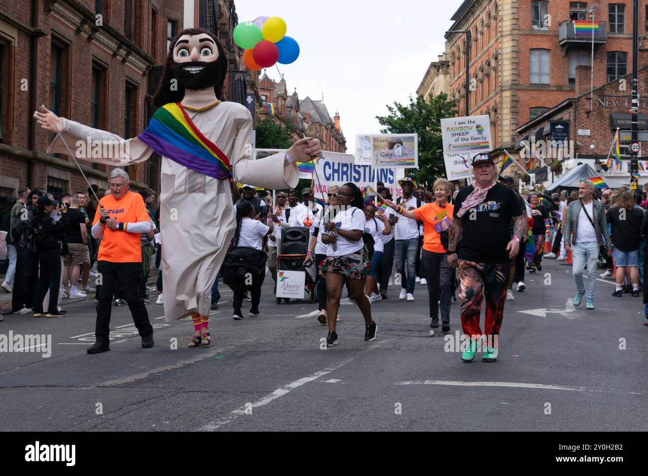 Défilé de la fierté, Manchester. Marionnette géante Jésus. Participants de l'Église métropolitaine. Banque D'Images