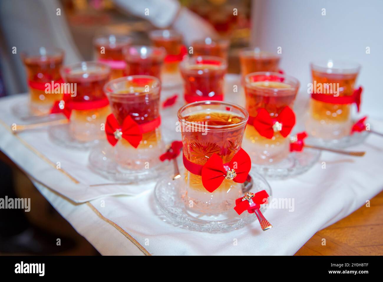 Thé en verre armudu traditionnel azerbaïdjanais en forme de poire . Thé filtré pour l'engagement. fermé avec un ruban rouge . vérifier le noeud papillon . Thé noir turc i. Banque D'Images