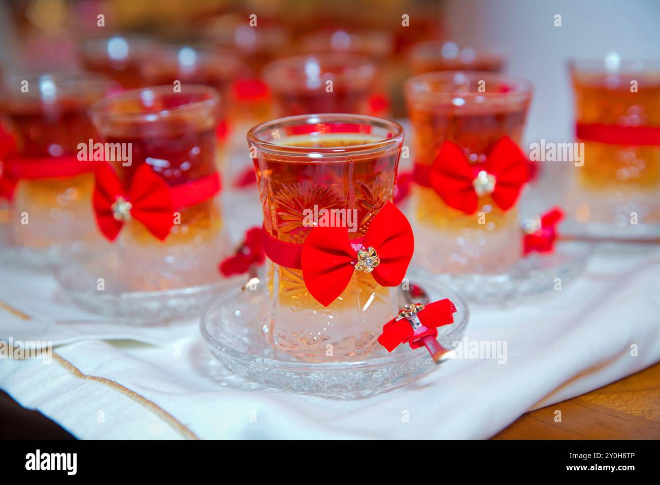 Thé en verre armudu traditionnel azerbaïdjanais en forme de poire . Thé filtré pour l'engagement. fermé avec un ruban rouge . vérifier le noeud papillon . Thé noir turc i. Banque D'Images