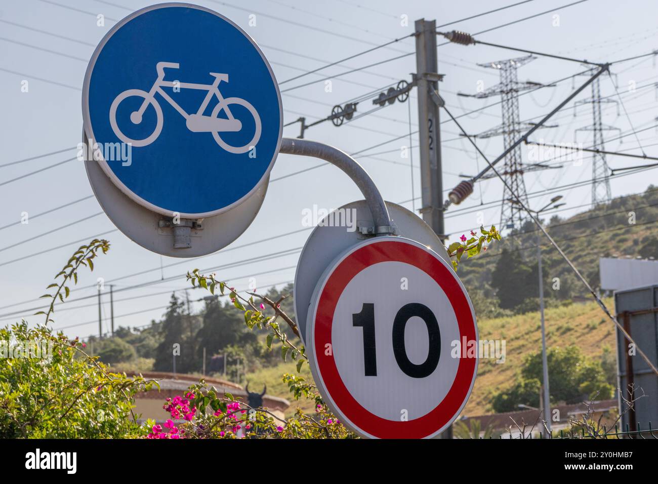 Un panneau de bicyclette et un panneau de limitation de vitesse sont debout dans un environnement urbain, suggérant de mettre l'accent sur le transport durable et les déplacements quotidiens respectueux de l'environnement Banque D'Images