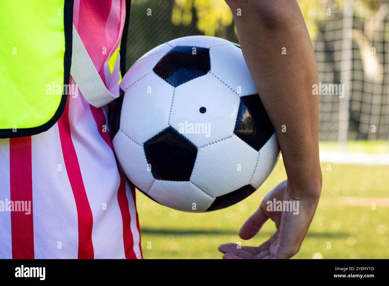 Tenant le ballon de football, personne debout sur le terrain portant un maillot de sport Banque D'Images