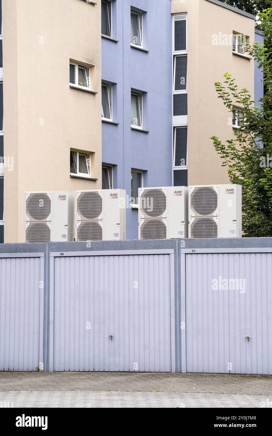 Pompes à chaleur dans un quartier résidentiel, les maisons multifamiliales sont alimentées en chauffage, en refroidissement et en eau chaude sanitaire via ces appareils, installés sur le garage Banque D'Images