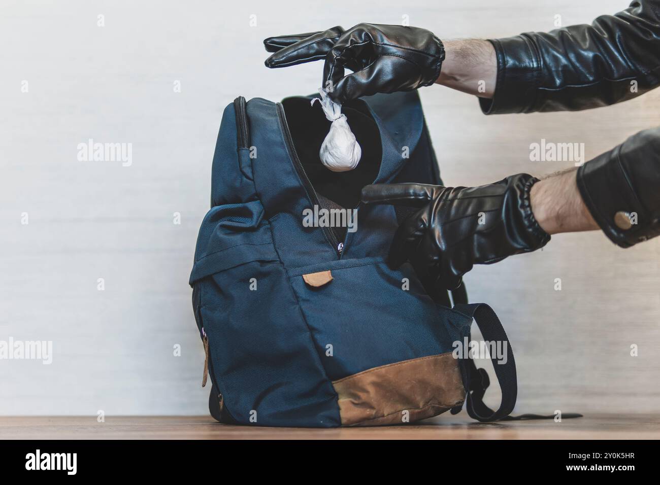 un employé de l'aéroport fouille le sac à dos d'un touriste et trouve un sac de poudre blanche. Exposer un livreur de médicaments. Arrestation de trafiquants de drogue. Un agent de police s Banque D'Images