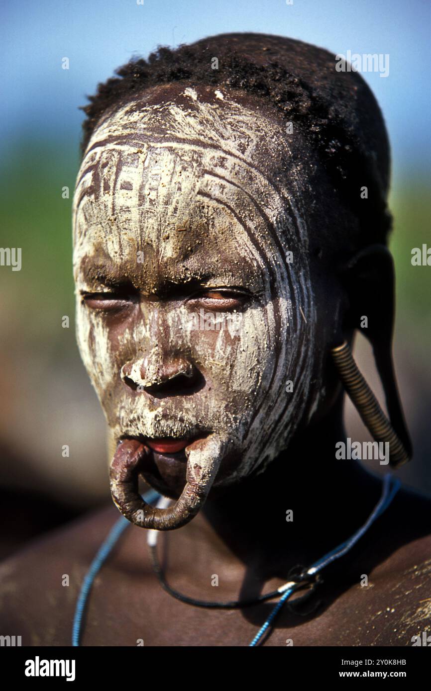 Portrait d'une femme Mursi qui a enlevé sa plaque de lèvre de sa lèvre inférieure. la couleur cendre blanche couvre le visage afin d'effrayer les tribus rivales. Banque D'Images