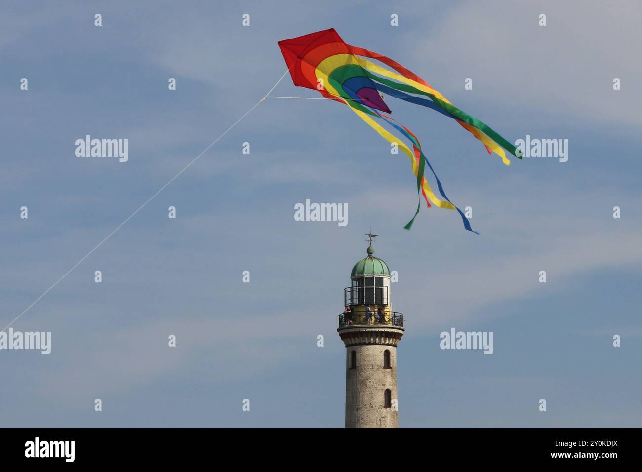 Blick am Mittwoch 14.08.2024 im Ostseebad Warnemünde, ein Ortsteil der Hanse- und Universitätsstadt Rostock, BEI sommerlichem Wetter auf den historischen Leuchtturm während davor ein Tourist einen Drachen steigen lässt. In den Urlaubsorten entlang der Ostseeküste des Landes Mecklenburg Vorpommern herrscht derzeit reges Treiben. In direkter Strandnähe ist fast kein freier Platz mehr zu finden und die restaurants sind gut besucht. Dennoch bleibt ein Wermutstropfen. Die Preise in den Tourismusregionen des Landes MV sind in diesem Jahr noch einmal gestiegen. DAS hält zahlreiche Menschen jedoch nic Banque D'Images
