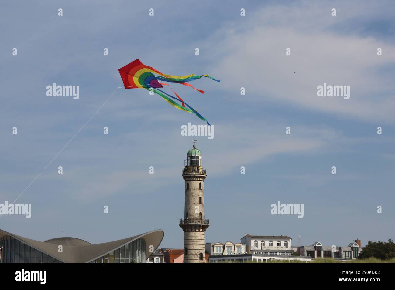Blick am Mittwoch 14.08.2024 im Ostseebad Warnemünde, ein Ortsteil der Hanse- und Universitätsstadt Rostock, BEI sommerlichem Wetter auf den historischen Leuchtturm während davor ein Tourist einen Drachen steigen lässt. In den Urlaubsorten entlang der Ostseeküste des Landes Mecklenburg Vorpommern herrscht derzeit reges Treiben. In direkter Strandnähe ist fast kein freier Platz mehr zu finden und die restaurants sind gut besucht. Dennoch bleibt ein Wermutstropfen. Die Preise in den Tourismusregionen des Landes MV sind in diesem Jahr noch einmal gestiegen. DAS hält zahlreiche Menschen jedoch nic Banque D'Images