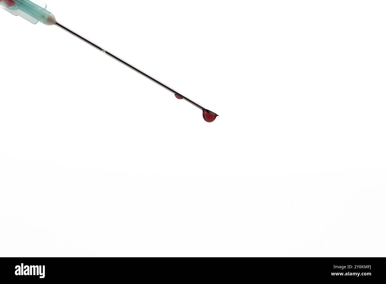 Vue rapprochée d'une aiguille de seringue avec une goutte de sang sur l'extrémité, centrée sur l'image horizontale. La toile de fond blanche améliore la mise au point sur l'aiguille' Banque D'Images