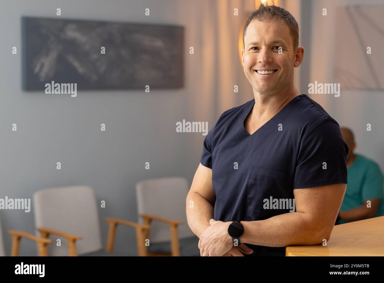 Médecin masculin souriant, travailleur de la santé dans les gommages en clinique médicale, en attente des patients, espace de copie Banque D'Images