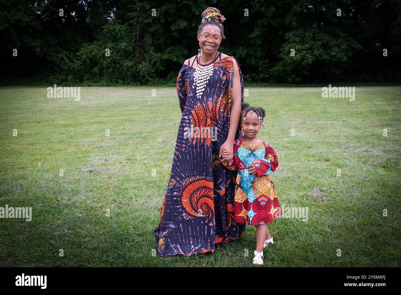 Une jeune mère et vendeuse à la Wakanda Celebration annuelle portant des vêtements distinctifs ouest-africains. Avec sa fille à Mount Vernon, Westchester. Banque D'Images