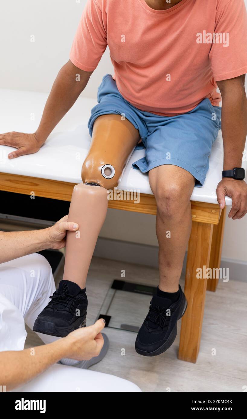 Pose d'une jambe prothétique, technicien assistant le patient en laboratoire médical Banque D'Images