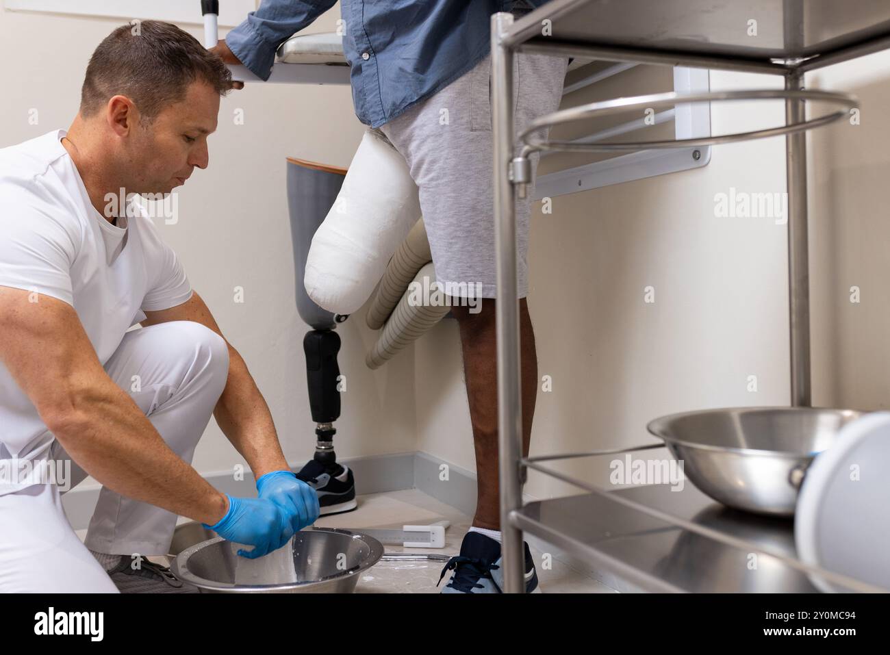 Technicien en laboratoire prothétique ajustant la jambe prothétique pour patient en clinique Banque D'Images