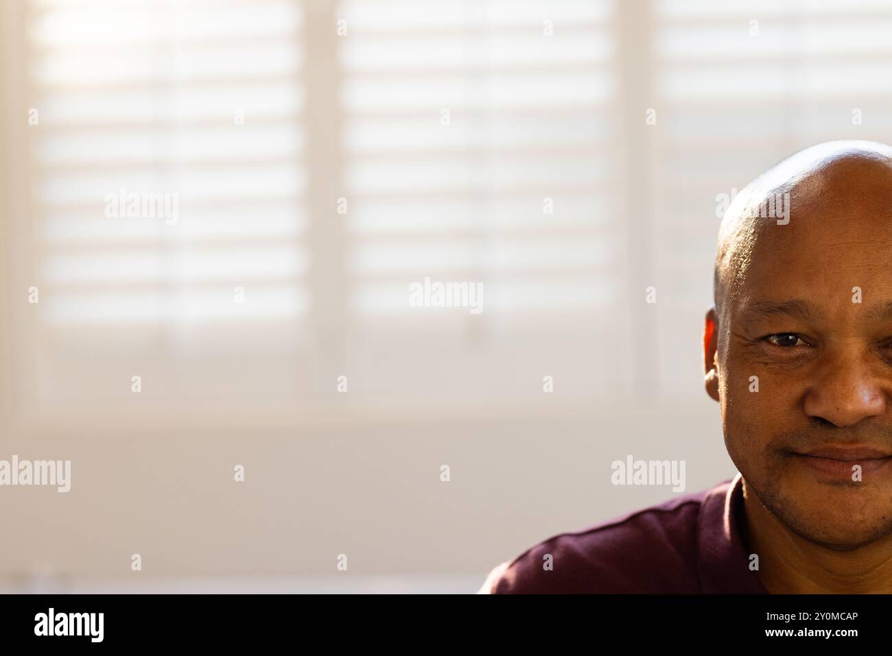 Homme souriant dans une clinique médicale prothétique, se concentrant sur le travail avec une fenêtre lumineuse derrière, un espace de copie Banque D'Images