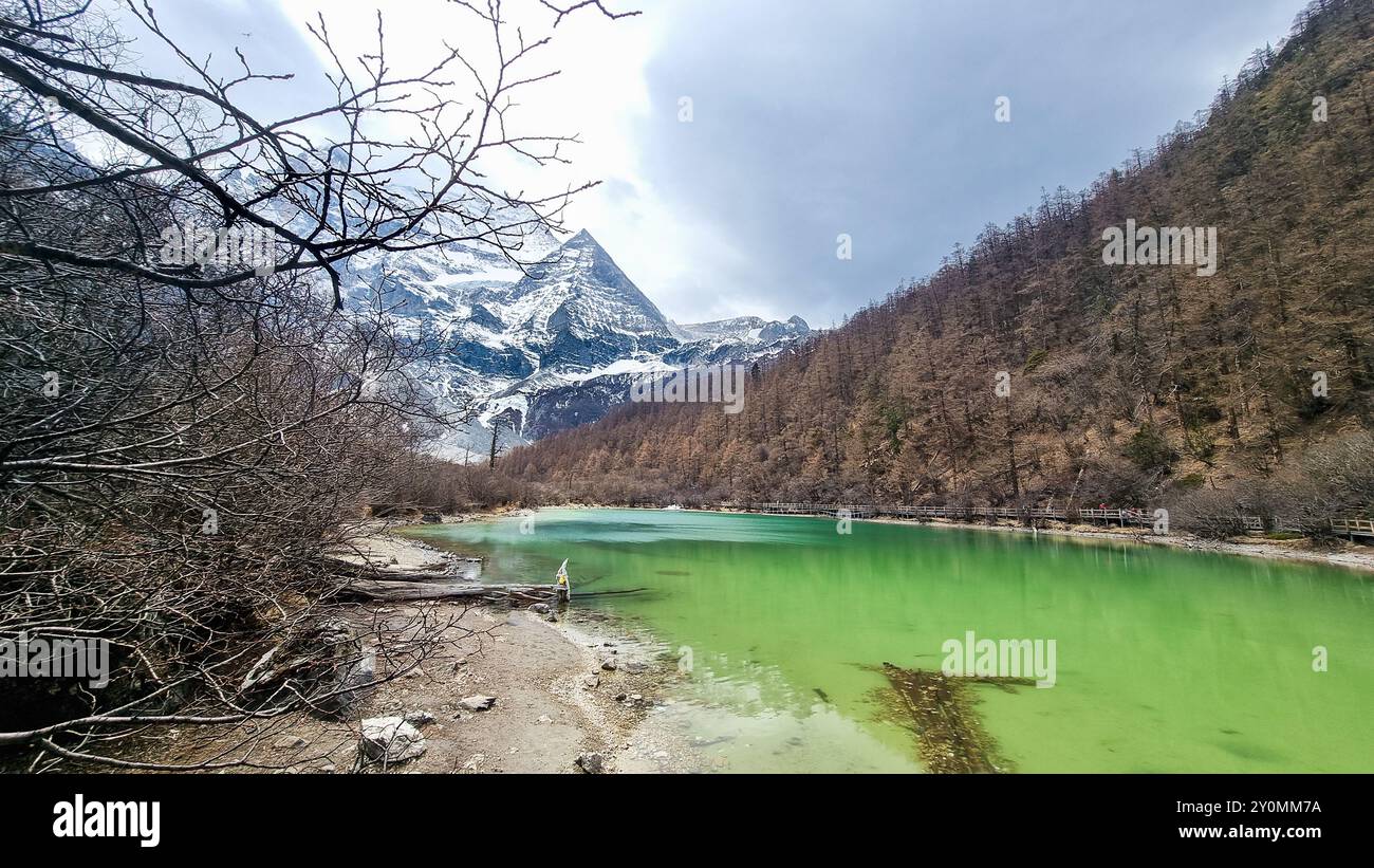 Lac perlé pittoresque avec de l'eau de couleur verte avec le mont Xiannairi comme toile de fond à la réserve naturelle de Yading, Sichuan Banque D'Images