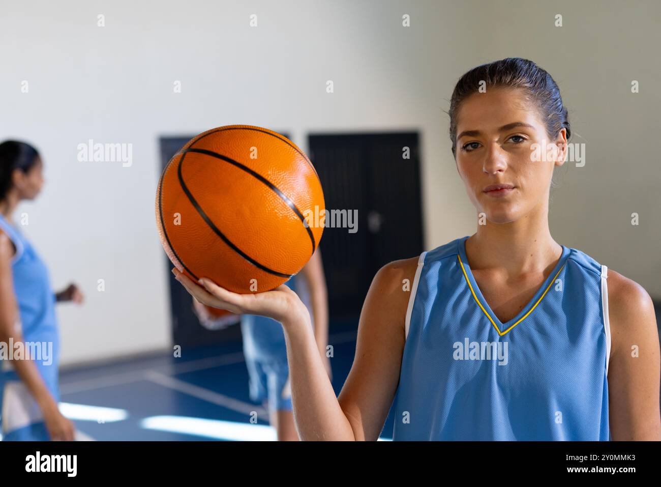 Tenue de basket-ball, athlète féminine en uniforme debout sur un court couvert Banque D'Images