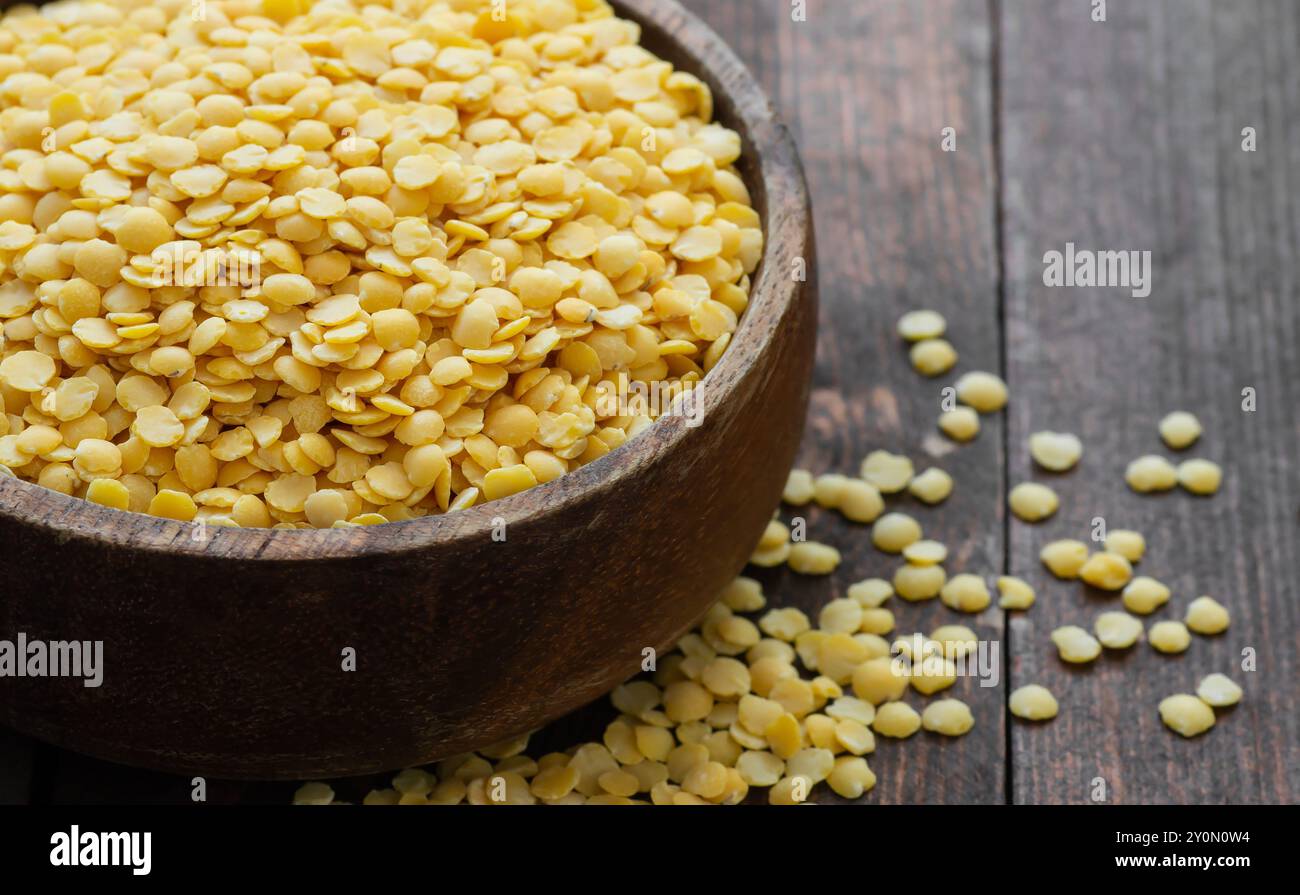Lentille jaune crue non cuite dans un bol sur fond en bois, (Lens culinaris) Banque D'Images