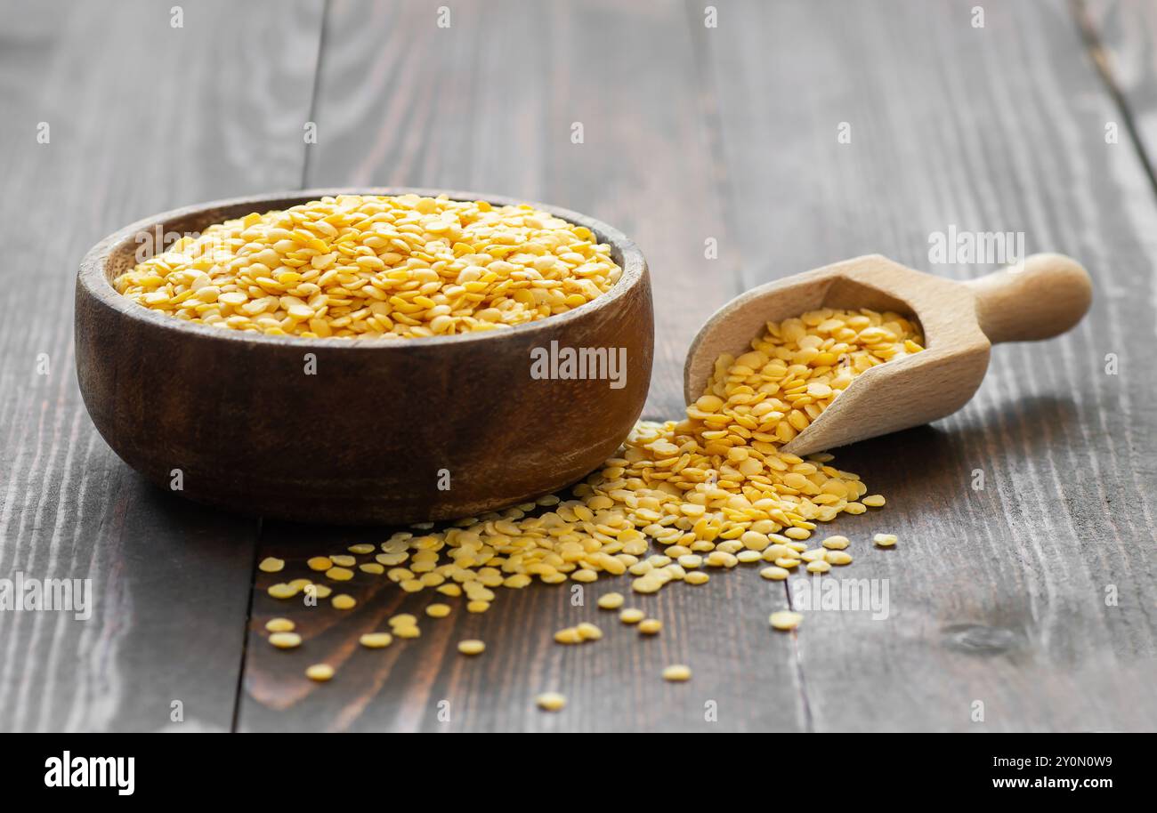 Lentille jaune crue non cuite dans un bol sur fond en bois, (Lens culinaris) Banque D'Images
