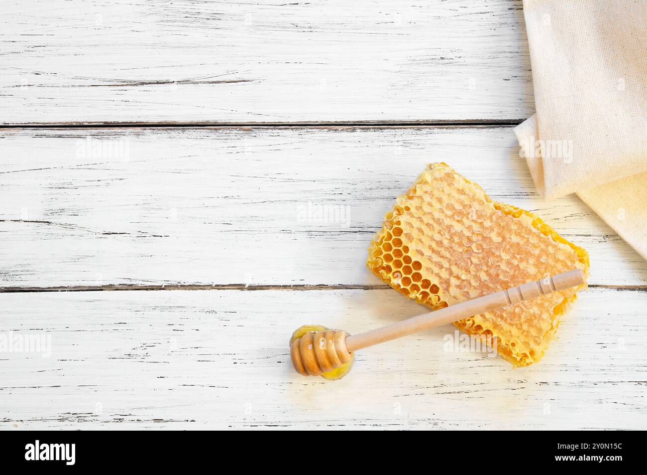 Morceau de miel frais biologique en nid d'abeille avec une trempette sur fond rustique, nourriture saine Banque D'Images