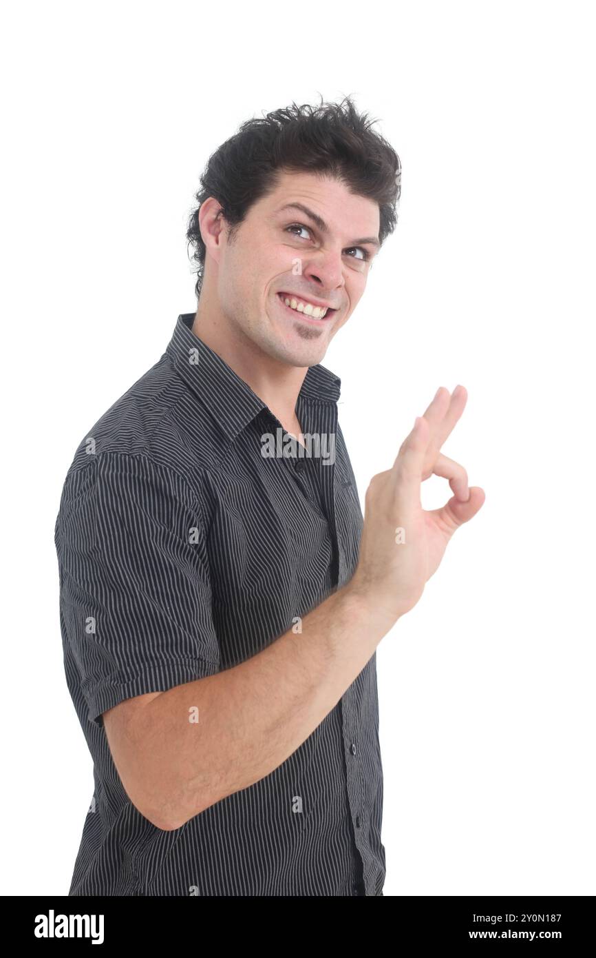 jeune homme avec le sourire maléfique montrant le signe ok sur fond blanc isolé Banque D'Images