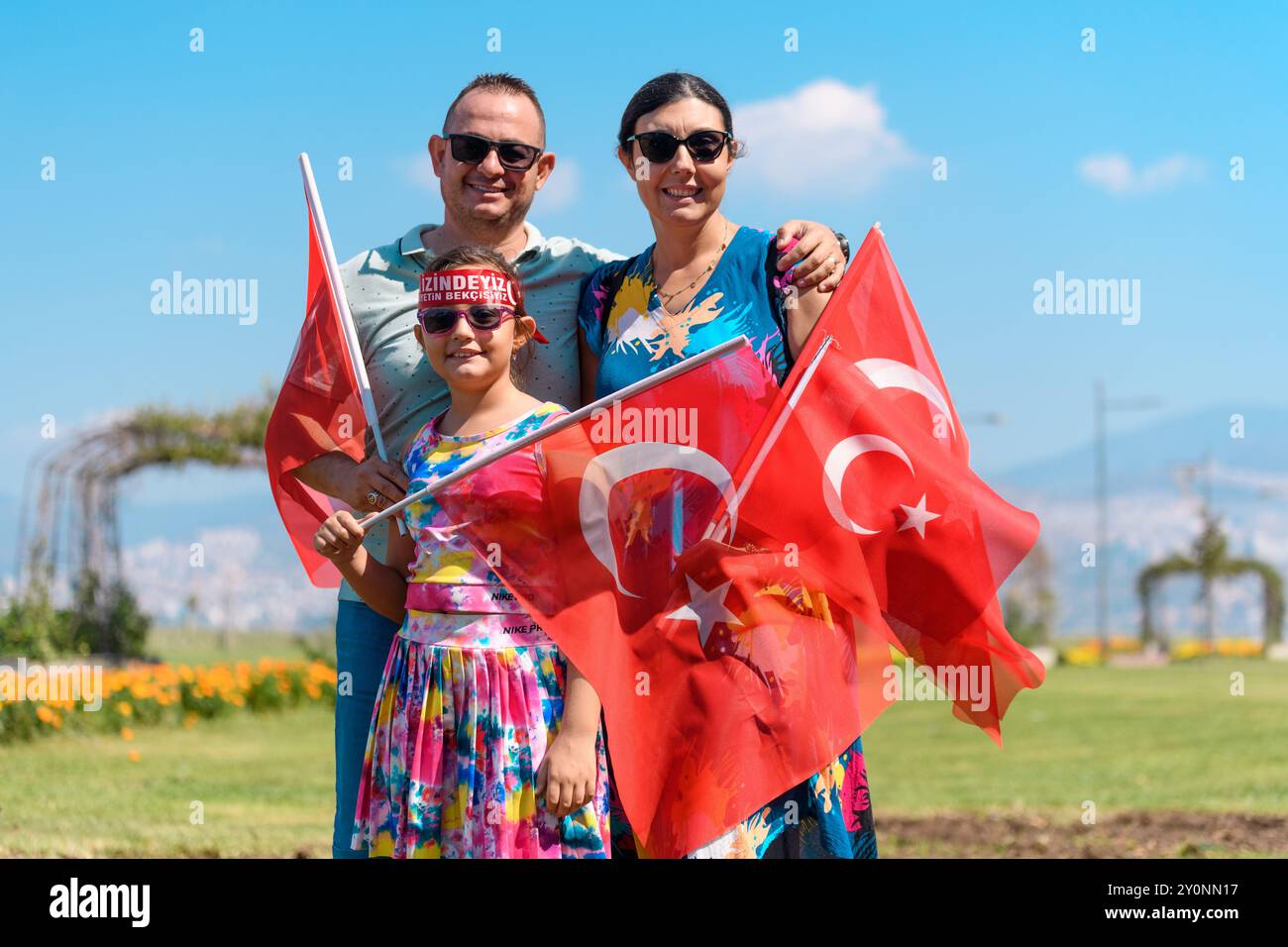 Izmir, Turquie - août 30 2024 : une famille célébrant le jour de la victoire à Cumhuriyet Square, Alsancak Kordon en arrière-plan. Mère, père et enfant ho Banque D'Images