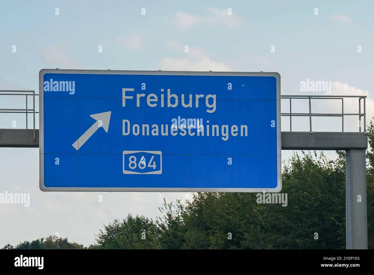Autobahnschild, Zielangaben, Richtung Freiburg, Donaueschingen, Autobahn 864, blaue Hintergrundfarbe, weiße Schrift, Pfeil nach links oben, Verkehrsanweisung, Hinweisschild, Ausfahrtanzeige, Autobahnbrücke im Hintergrund, Beschilderung auf deutscher Autobahn, Navigationshilfe, Verkehrsinfrastruktur, Straßenschild, Orientierungshilfe, Fahrtzielanzeige, Transportnetzwerk, Fahrtrichtung, deutsche Straßenbeschilderung, Wegweiser für Autofahrer. *** Panneau de l'autoroute, informations sur la destination, direction Freiburg, Donaueschingen, autoroute 864, couleur de fond bleu, lettrage blanc, flèche vers le haut à gauche, trafic Banque D'Images