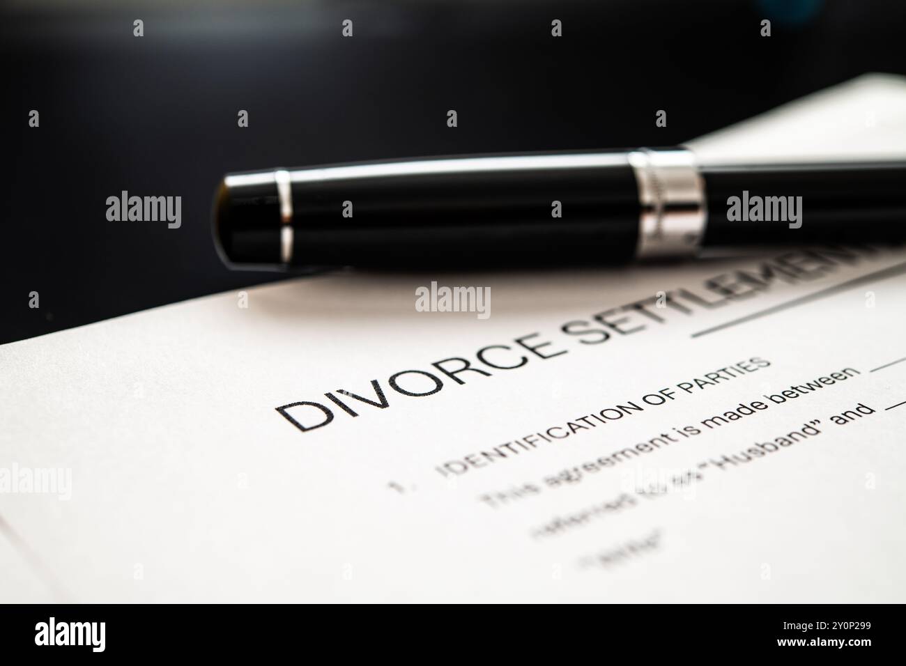 Un gros plan d'un accord de règlement de divorce et un stylo élégant, mettant l'accent sur le processus juridique impliqué dans la dissolution du mariage et associé Banque D'Images