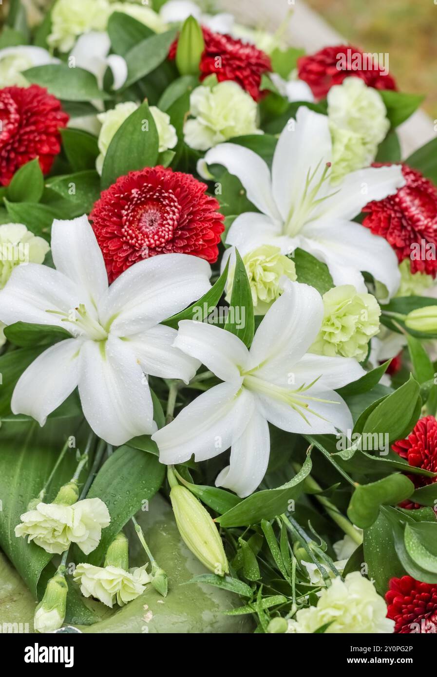 Belles fleurs tombales dans le cimetière. Les parents veulent se souvenir du défunt avec des fleurs. Un beau bouquet réconforte les parents en deuil. Banque D'Images