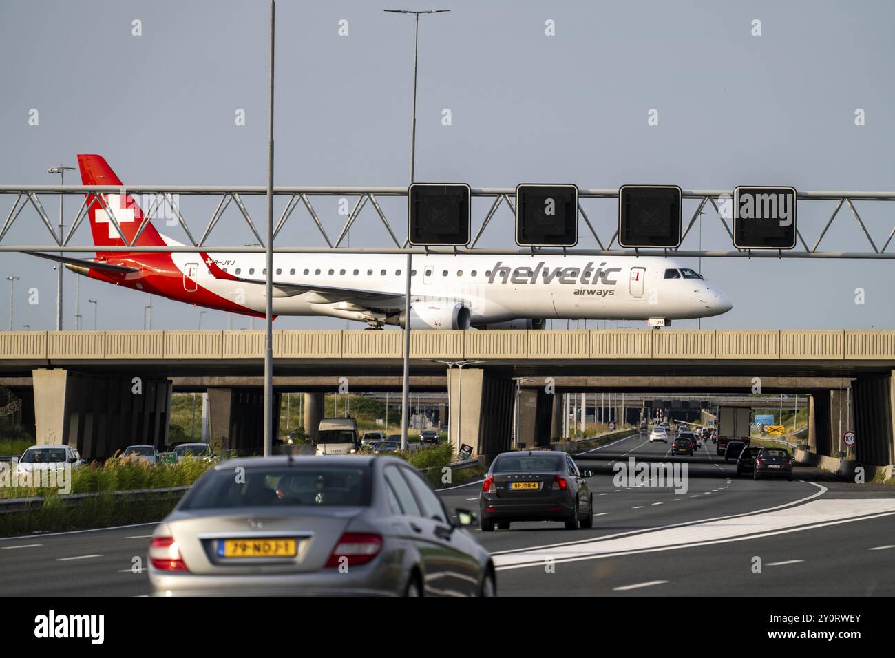 Aéroport d'Amsterdam Schiphol, Helvetic Airways Embraer ERJ-195, avion sur la voie de circulation, pont sur l'autoroute A4, connexion depuis la piste Polderbaan Banque D'Images