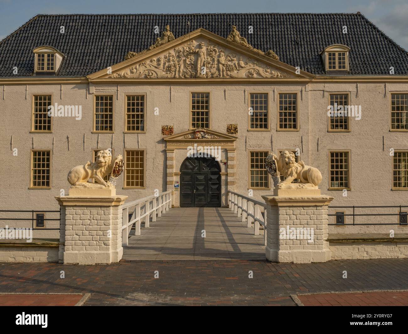 Manoir historique avec statues de lion et ornement décoratif de pignon, accessible via un petit pont, dornum, frise orientale, allemagne Banque D'Images