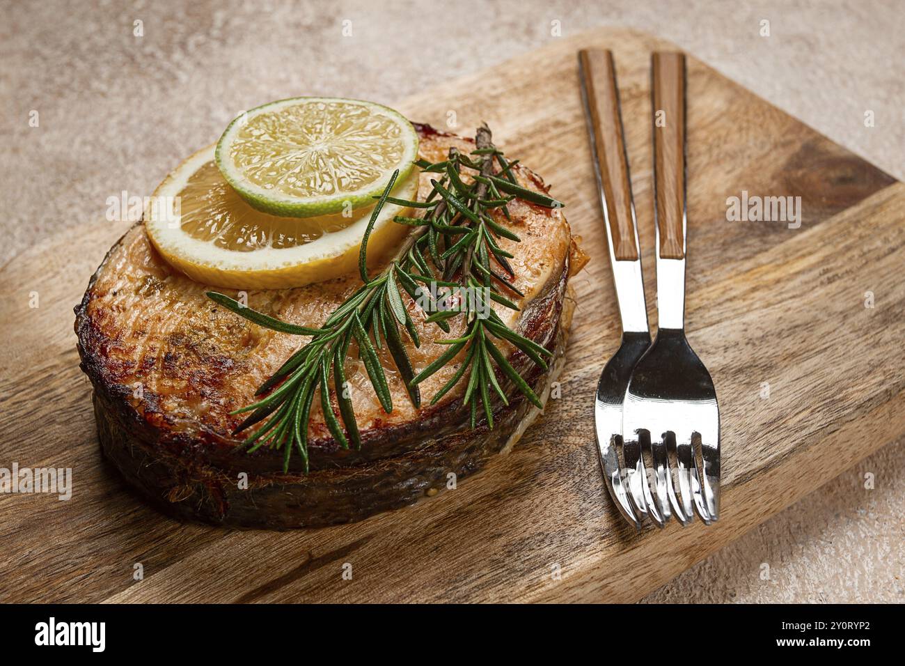 Steak de saumon, frit, sur une planche à découper, vue de dessus, romarin, citron et citron vert, fait maison, un seul service, pas de gens Banque D'Images