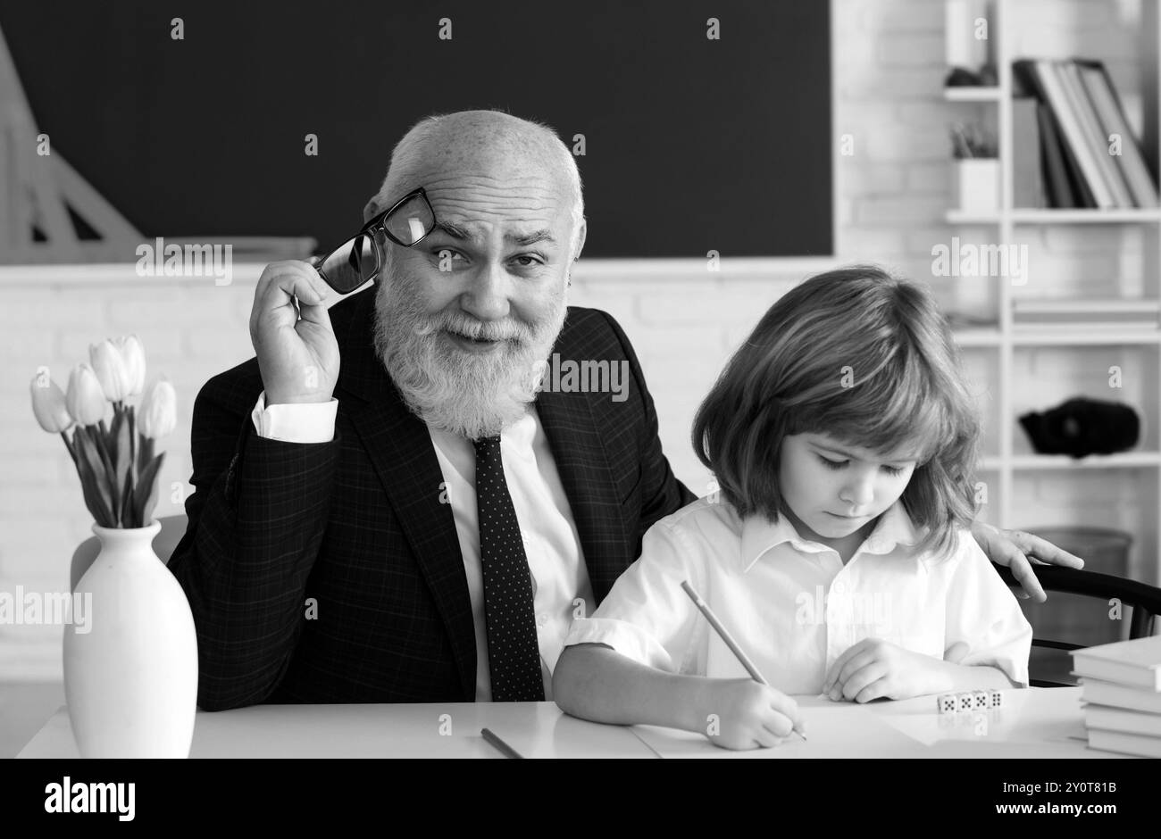 Aide à apprendre. Ancien enseignant avec élève. Leçon scolaire. Concept d'éducation. Ancien enseignant avec un élève en classe. Banque D'Images