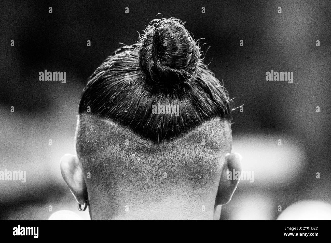 Coup de projecteur sur scène : gros plan sur la coiffure d'un petit pain de jeune homme : rasage partiel, performance nocturne. Banque D'Images