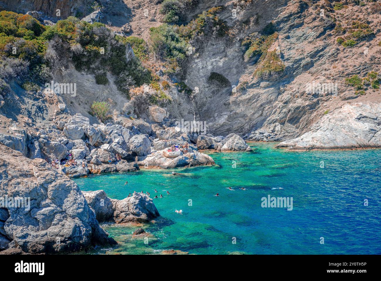 Nageurs sur la plage d'Agia Anna, une petite plage rocheuse d'une beauté spectaculaire sur l'île d'Amorgos, Cyclades, Grèce. Banque D'Images