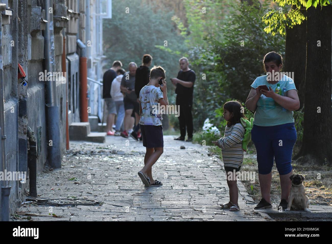 LVIV, UKRAINE - 4 SEPTEMBRE : des gens se tiennent sur le site d'une frappe de missile russe le 4 septembre 2024 à Lviv, Ukraine. L'armée russe a mené une attaque de missiles à grande échelle sur les villes ukrainiennes. À Lviv, la grève a entraîné la destruction de bâtiments résidentiels et la mort d'au moins sept personnes, dont trois enfants. Banque D'Images