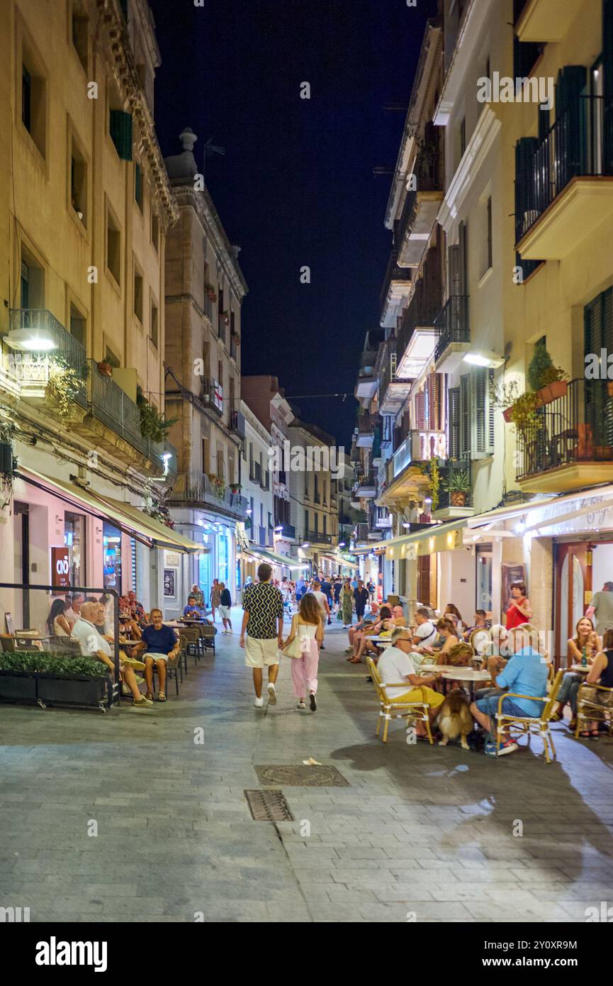 Sitges, Barcelone-04 septembre 2024 : la vie sociale se déroule subtilement dans cette photographie prise lors d’une promenade nocturne à Sitges. Banque D'Images