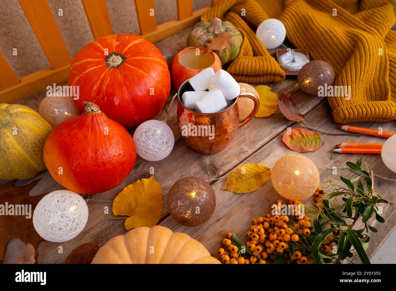 Feuilles jaunes d'automne, citrouille, guimauves dans une tasse sur la table, concept de fête, ambiance automnale confortable, préparation d'Halloween, décor d'automne et créativité Banque D'Images