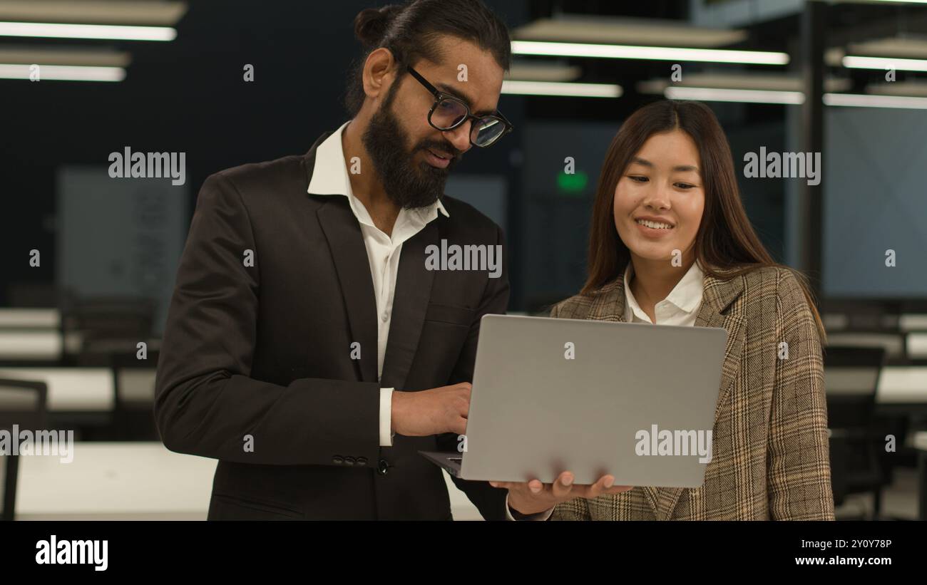 Divers collègues multiraciaux gens d'affaires dans le bureau discutant de nouveau projet de démarrage d'ordinateur portable en ligne Indian Arabian businessman mentor consulter parler Banque D'Images
