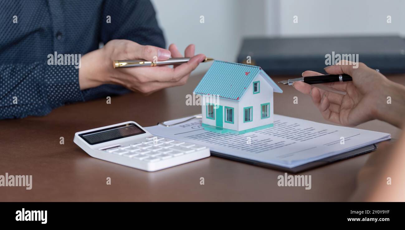 Discuter des détails du contrat immobilier avec un modèle de maison Banque D'Images
