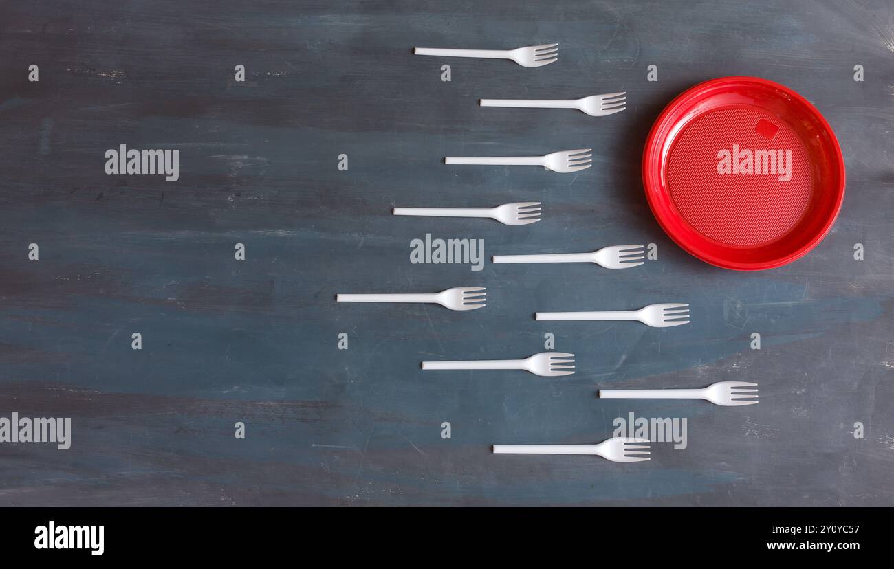 Fourchettes en plastique blanches à usage unique et assiettes pastiques rouges. Pose à plat avec espace de copie libre. N'utilisez pas de plastique à usage unique pour les aliments à emporter. po. Environnement Banque D'Images