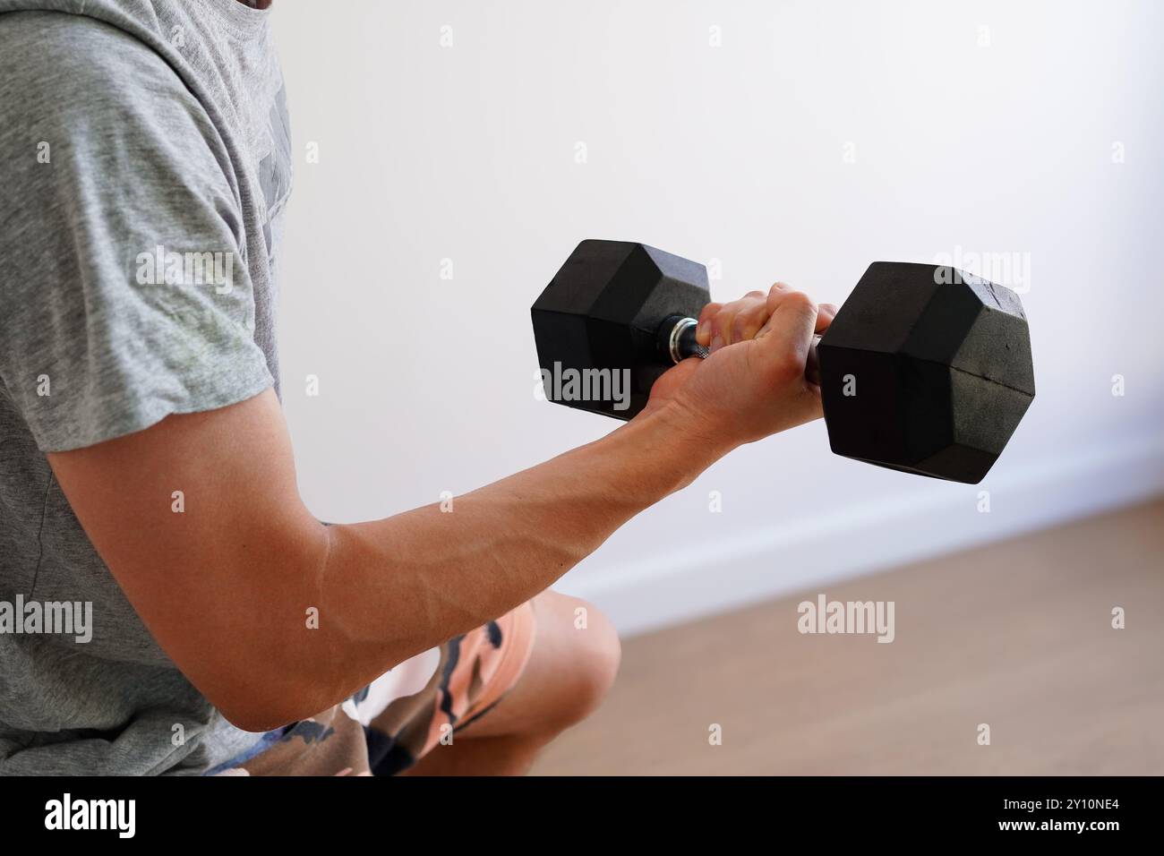 Homme faisant de la musculation avec des haltères à la maison Banque D'Images