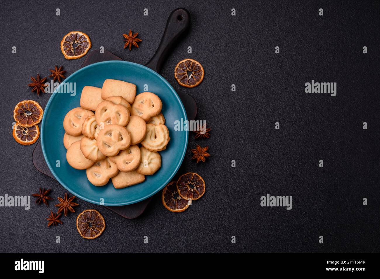 Délicieux biscuits au beurre croustillant doux frais sur une plaque en céramique sur un fond de béton foncé Banque D'Images