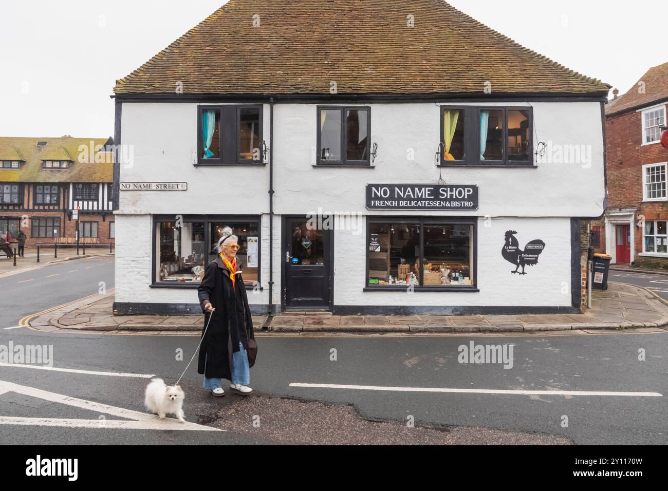 Angleterre, Kent, Sandwich, scène de rue avec femme promenant petit chien Banque D'Images