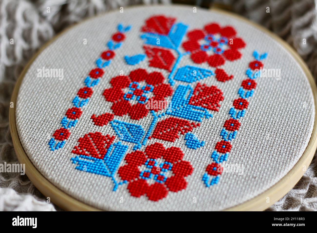 Broderie ukrainienne, 'vyshyvka', de l'est de l'Ukraine où les fleurs bleues et rouges dominent sur les motifs géométriques traditionnels noir et rouge. Banque D'Images