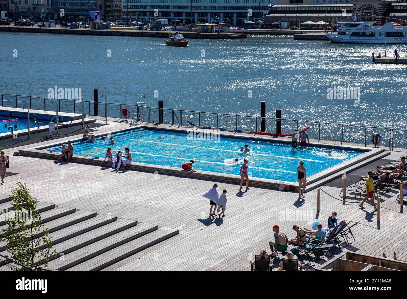 La veille de la mi-été dans la ville : les gens nagent et prennent le soleil sur la terrasse flottante d'Allas se Pool à Helsinki, en Finlande Banque D'Images