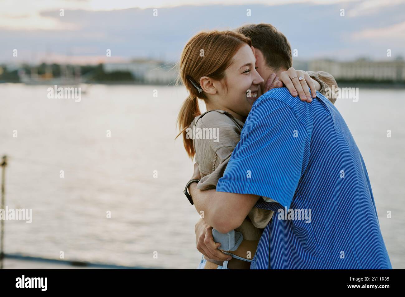 Couple embrassant près du paysage du front de mer pendant le coucher du soleil Banque D'Images