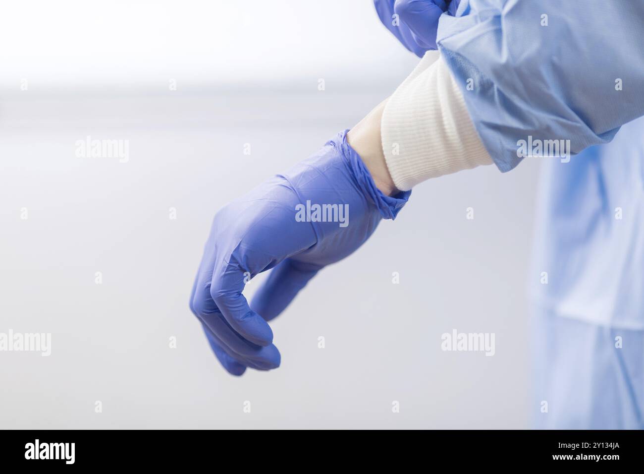 Médecin Chirurgien dans gants stériles à préparer l'opération à l'hôpital. Il porte la robe bleue et chirurgicale Banque D'Images