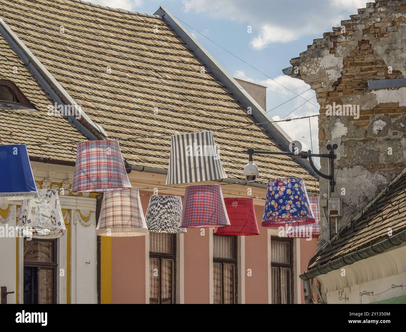 Des abat-jour colorés surplombent une rue pavée entre des maisons historiques aux toits de tuiles, esztergom, danube, hongrie Banque D'Images
