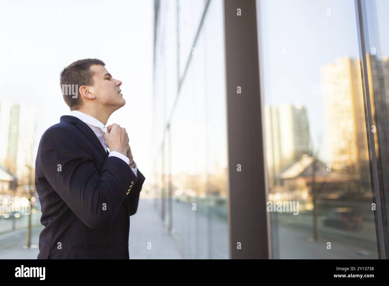 Jeune homme à lui-même dans le miroir de verre et le collier de réglage. Préparation pour l'entrevue d'emploi pour s'occuper d'affaires Banque D'Images