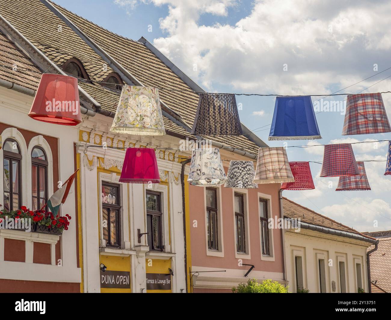Des abat-jour colorés surplombent une rue pittoresque avec des bâtiments historiques et des toits de tuiles, esztergom, danube, hongrie Banque D'Images