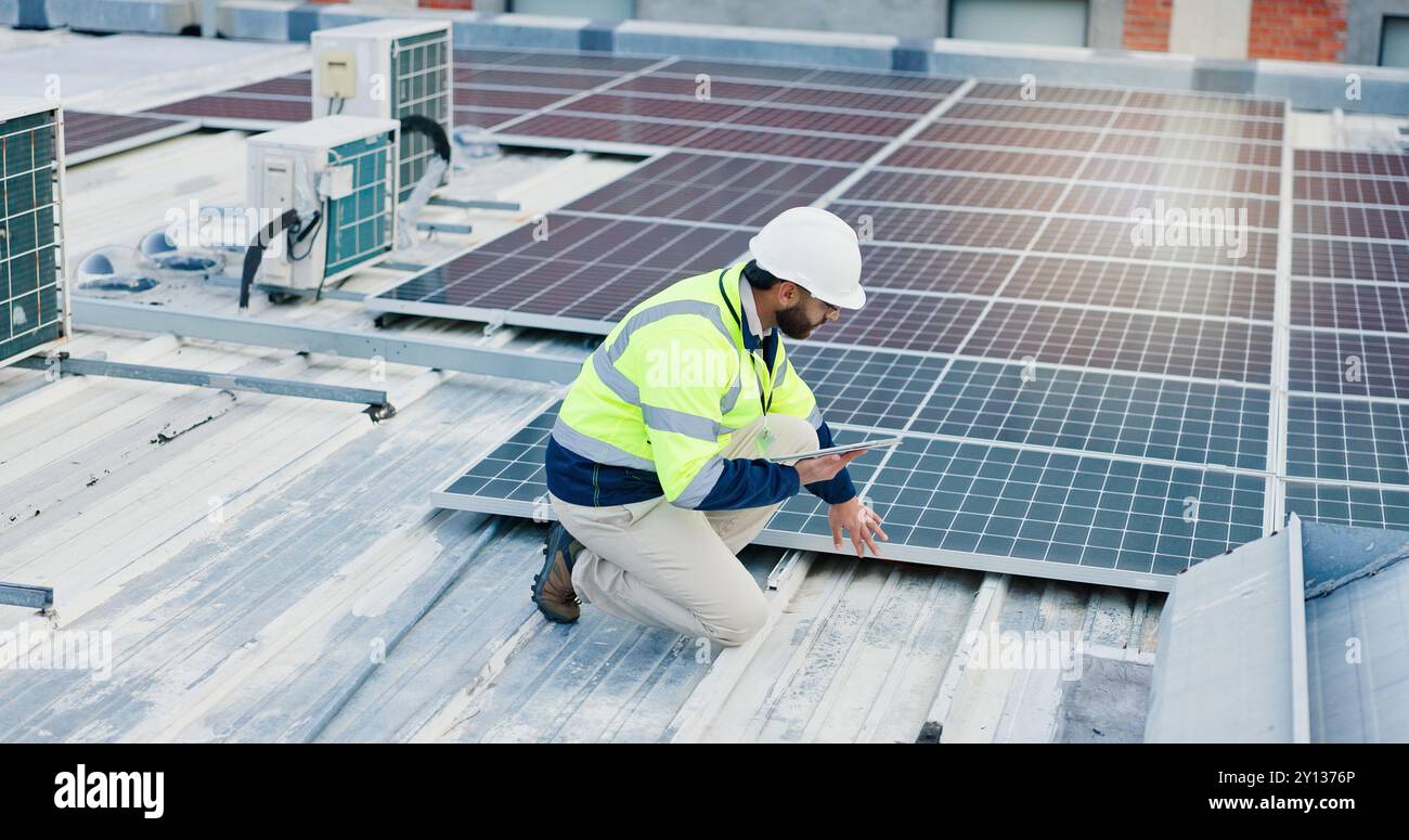 Ingénierie, homme et tablette pour panneaux solaires, économie d'énergie et électricité ou chauffage de grille écologique sur le toit. Technicien, technologie numérique Banque D'Images